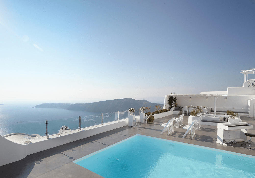 A serene pool and terrace at Erossea Villa Santorini, offering stunning views of the sea and mountains, perfect for weddings