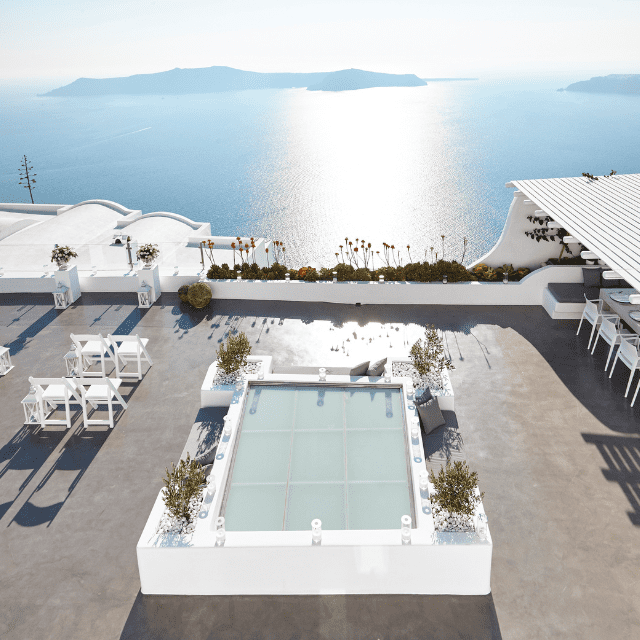 A sunlit rooftop terrace overlooking a calm sea and distant islands. The Erossea Villa terrace features a glass-bottomed square pool, white dining tables, potted plants, and a shaded seating area under a pergola.