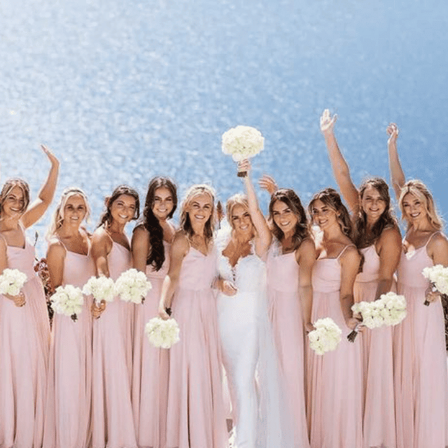 Bridesmaids in elegant pink dresses and veils, celebrating at Erossea Villa during a stunning Santorini wedding