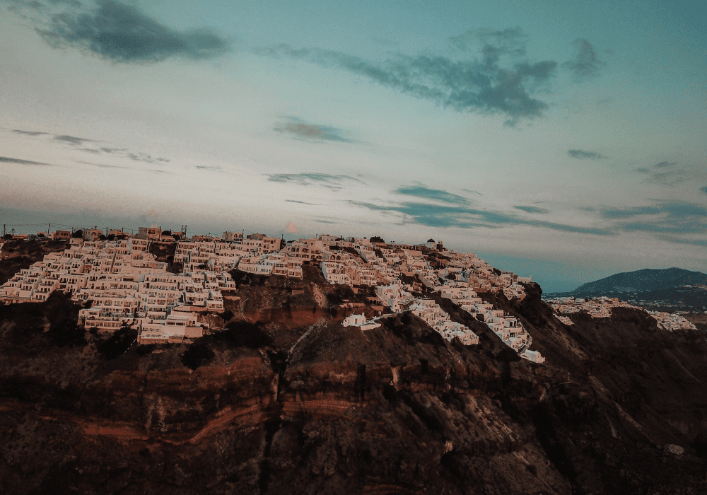 Scenic vista from Imerovigli cliff in Santorini, featuring the azure sea and iconic white architecture against a clear sky