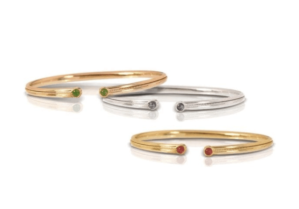 Three elegant gold and silver rings featuring green and red stones